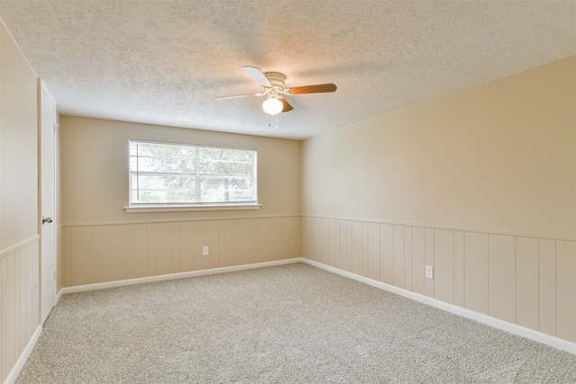 carpeted empty room featuring ceiling fan and a textured ceiling