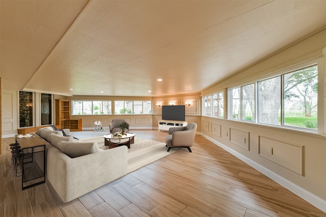 living room featuring light hardwood / wood-style floors, a wealth of natural light, and built in shelves