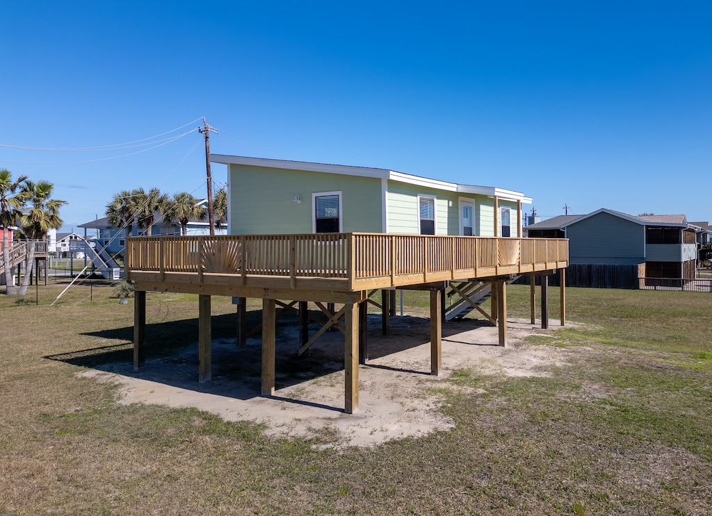 back of property featuring a playground, a yard, and a wooden deck