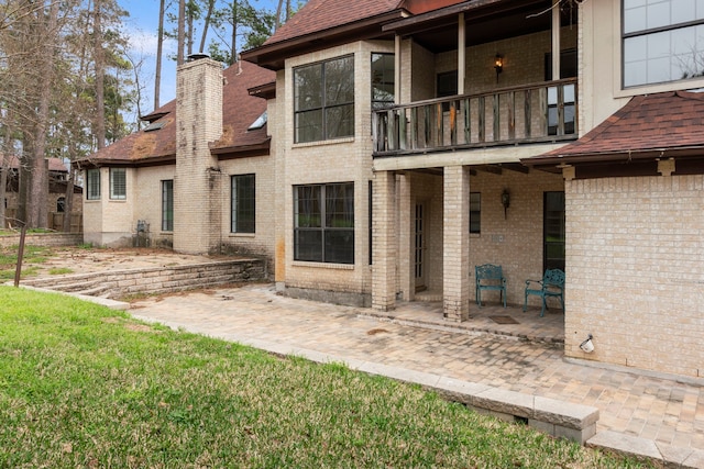 back of house featuring a balcony and a patio area