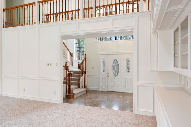 carpeted entryway featuring a high ceiling