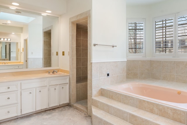 bathroom featuring a relaxing tiled bath and oversized vanity