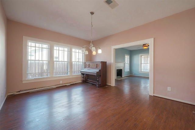 unfurnished living room featuring ceiling fan with notable chandelier and dark wood-type flooring