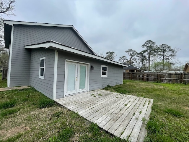 rear view of house featuring a lawn and a wooden deck