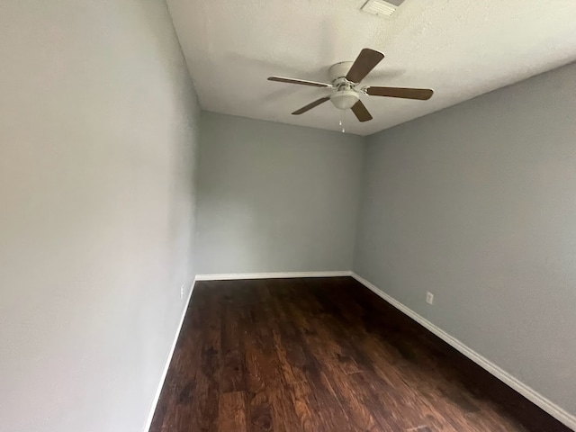 unfurnished room with ceiling fan and dark wood-type flooring