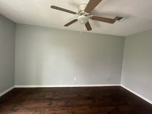 unfurnished room with a textured ceiling, dark hardwood / wood-style floors, and ceiling fan