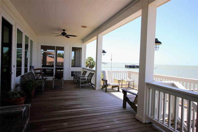 wooden terrace featuring ceiling fan and a water view