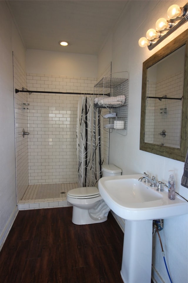 bathroom with curtained shower, hardwood / wood-style flooring, and toilet