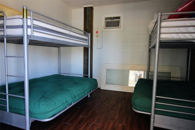 unfurnished bedroom with ornamental molding, a wall mounted AC, and dark wood-type flooring