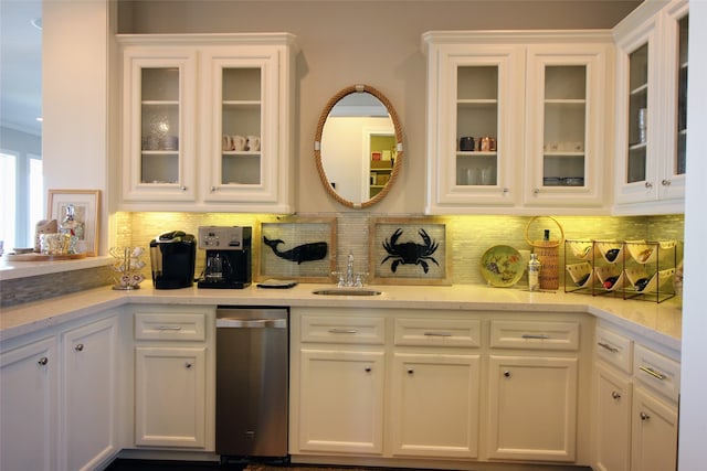 kitchen featuring dishwasher, white cabinets, sink, and tasteful backsplash