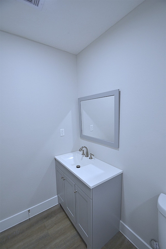 bathroom featuring hardwood / wood-style floors, vanity, and toilet