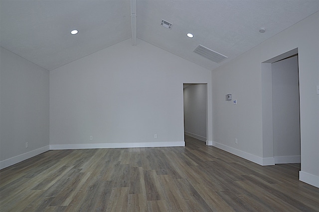 unfurnished room with vaulted ceiling with beams, a textured ceiling, and hardwood / wood-style flooring