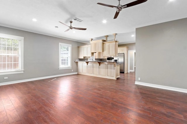 unfurnished living room featuring ceiling fan, hardwood / wood-style flooring, and a wealth of natural light