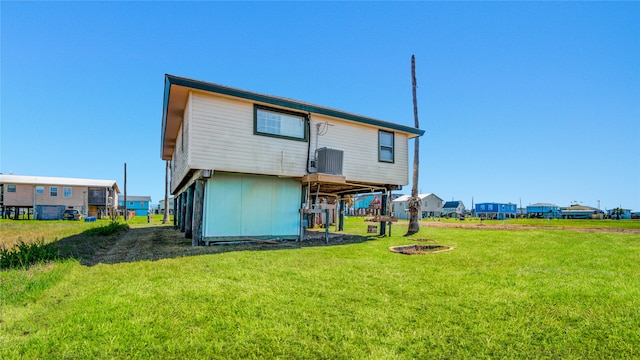 back of property featuring a lawn and an outdoor fire pit