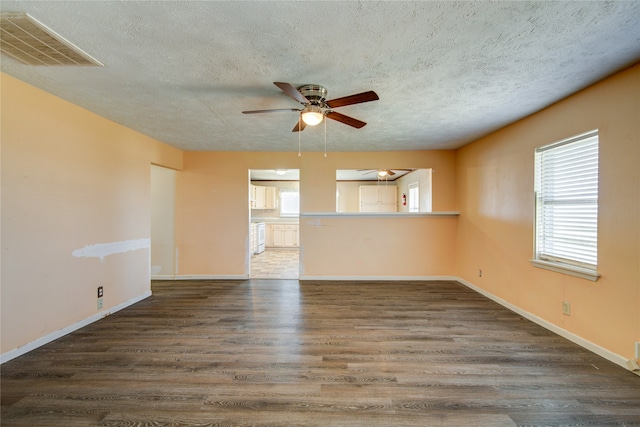 empty room featuring a textured ceiling, ceiling fan, and dark hardwood / wood-style floors