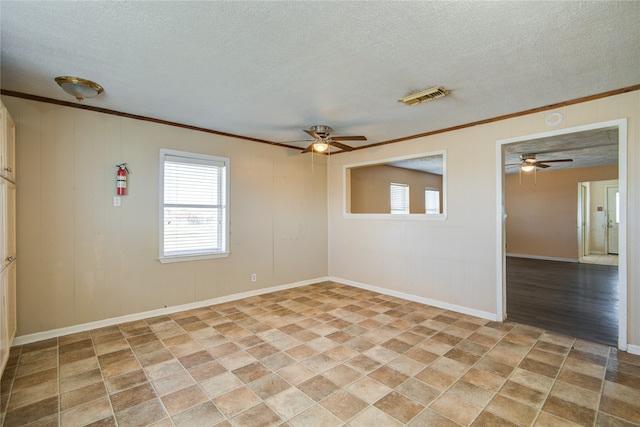 tiled empty room featuring ceiling fan, ornamental molding, and a textured ceiling