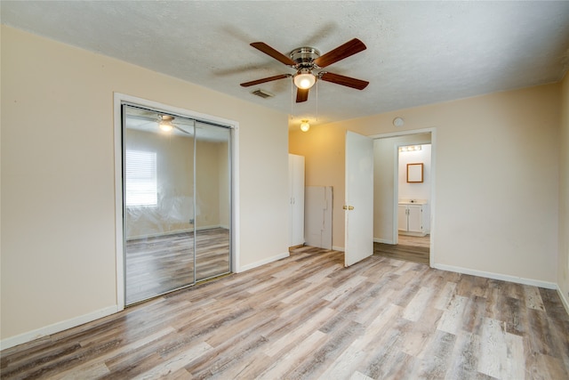 unfurnished bedroom with ceiling fan, light hardwood / wood-style flooring, and a closet