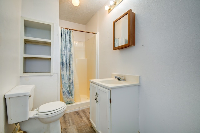 bathroom with hardwood / wood-style flooring, a shower with curtain, toilet, vanity, and a textured ceiling