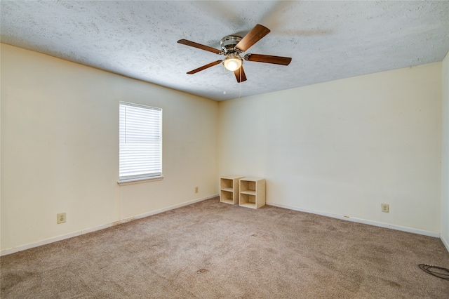 spare room with ceiling fan, a textured ceiling, and light carpet