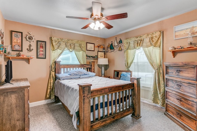 bedroom with ceiling fan, light colored carpet, and multiple windows