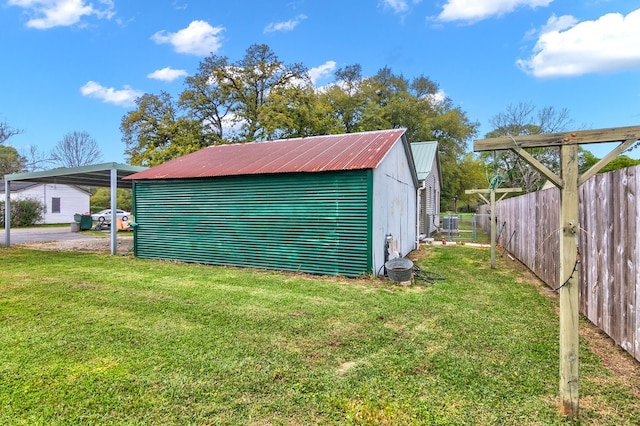 exterior space featuring a lawn, a carport, and an outdoor structure