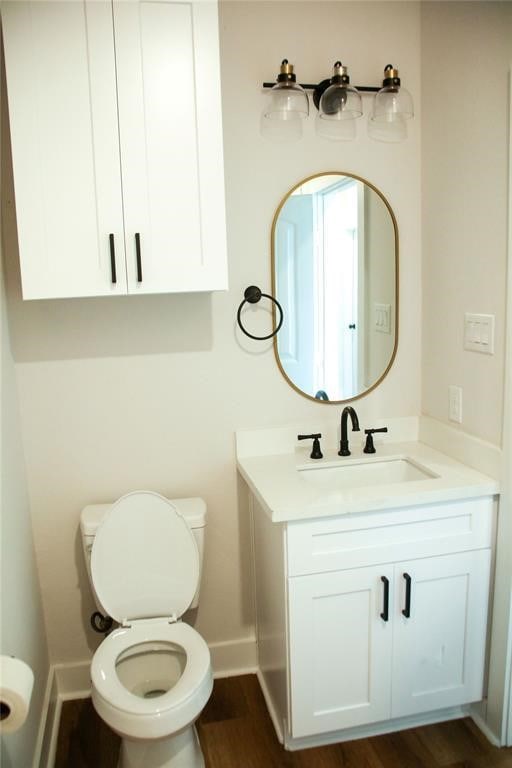 bathroom featuring vanity, wood-type flooring, and toilet