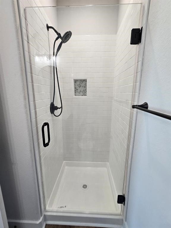 bathroom with a shower with door