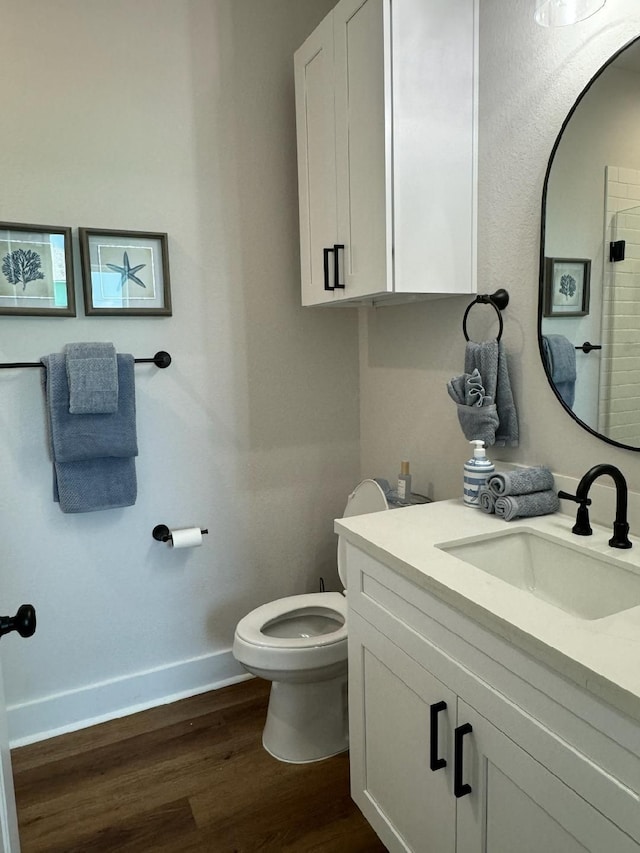 bathroom with vanity, wood-type flooring, and toilet