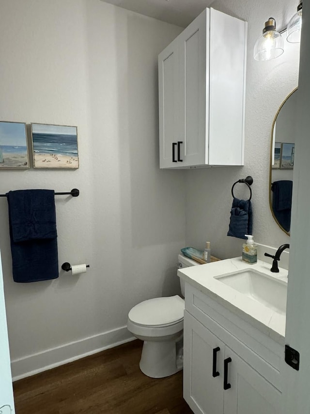 bathroom with vanity, hardwood / wood-style flooring, and toilet