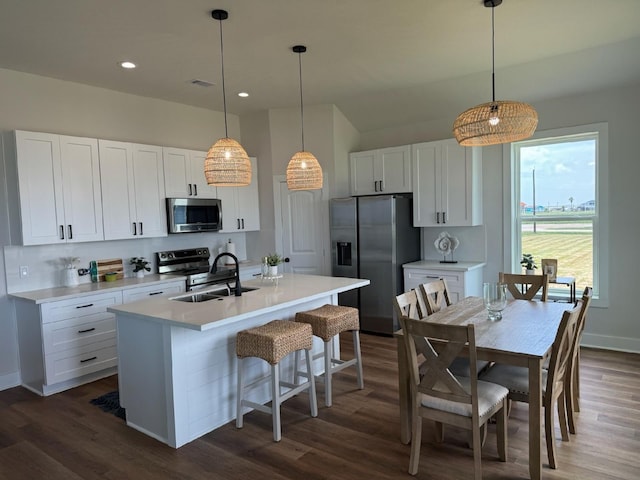 kitchen featuring sink, dark hardwood / wood-style floors, stainless steel appliances, and decorative light fixtures