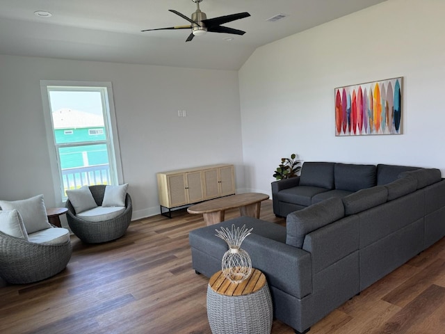 living room featuring dark hardwood / wood-style floors, ceiling fan, and vaulted ceiling