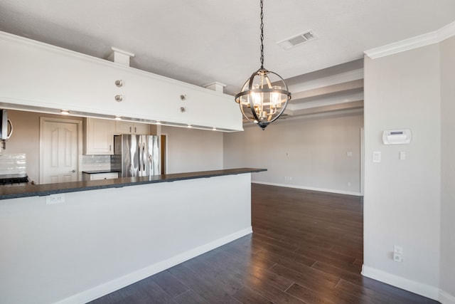 kitchen with pendant lighting, dark hardwood / wood-style flooring, a notable chandelier, tasteful backsplash, and stainless steel fridge