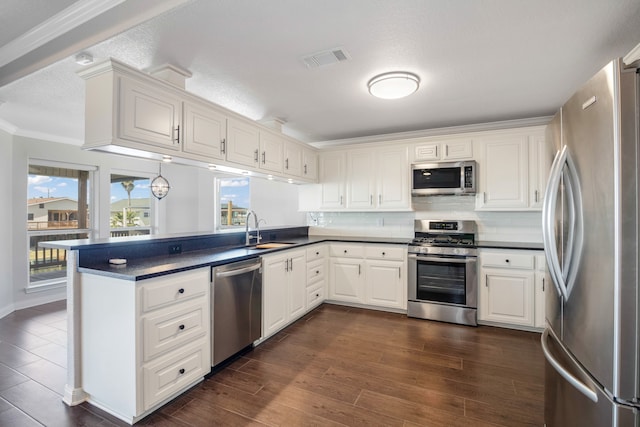 kitchen featuring stainless steel appliances, tasteful backsplash, white cabinetry, sink, and dark hardwood / wood-style flooring