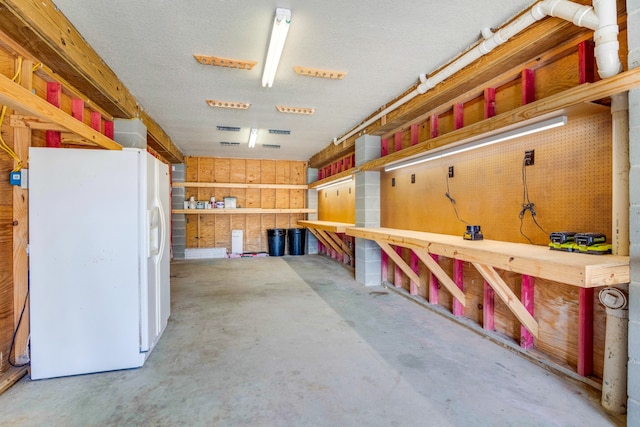 interior space with white refrigerator and a workshop area