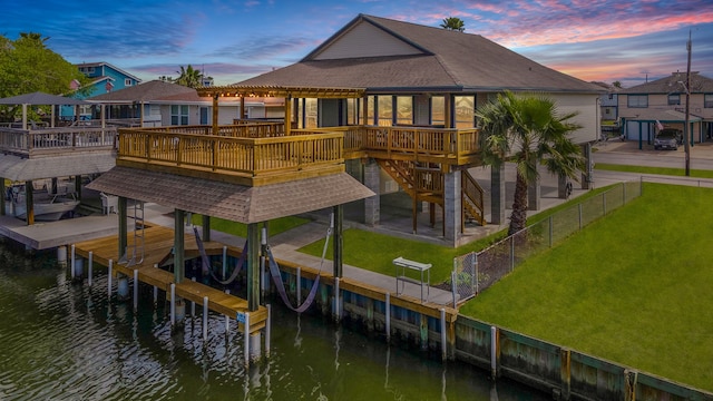 view of dock featuring a yard and a deck with water view