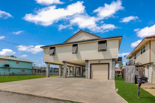 view of front of home featuring a carport, a garage, and a front lawn