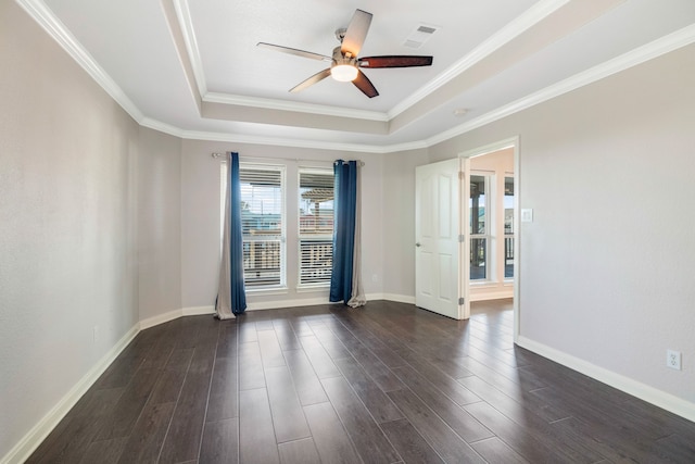 spare room featuring ceiling fan, a tray ceiling, dark hardwood / wood-style flooring, and crown molding