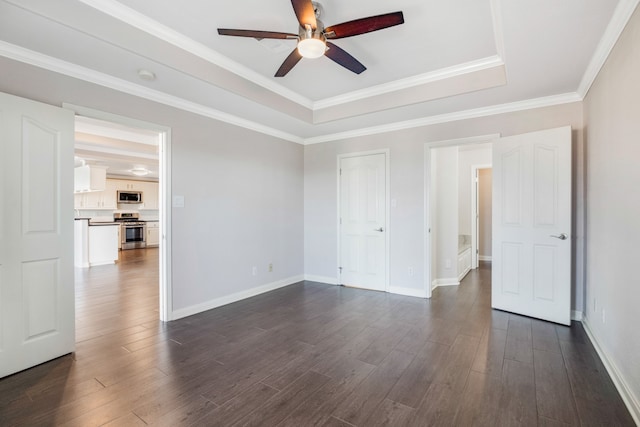 unfurnished room with a tray ceiling, dark hardwood / wood-style floors, ceiling fan, and crown molding