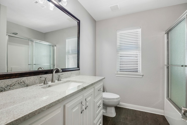 full bathroom with vanity, toilet, hardwood / wood-style flooring, and combined bath / shower with glass door