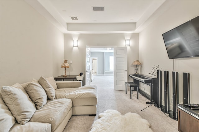 carpeted living room with a tray ceiling