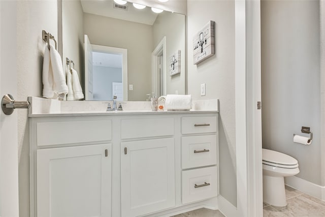 bathroom with toilet, tile flooring, and vanity