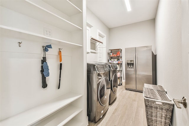 washroom featuring washing machine and dryer and light hardwood / wood-style flooring