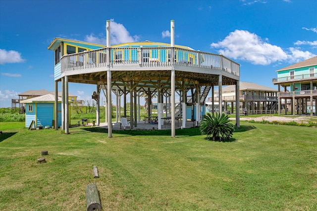 rear view of house with a lawn, a deck, an outdoor structure, and a patio