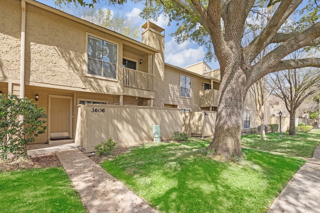 townhome / multi-family property with a balcony and a front yard