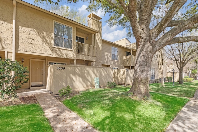 townhome / multi-family property with a balcony and a front yard
