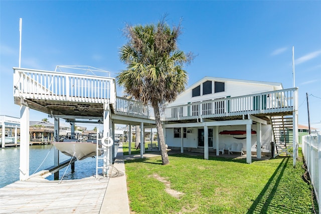 dock area with a deck with water view and a lawn