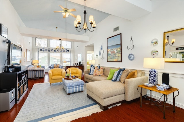 living room with ceiling fan with notable chandelier, dark hardwood / wood-style floors, and high vaulted ceiling