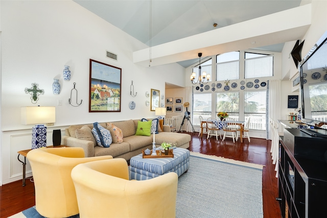 living room with a notable chandelier, high vaulted ceiling, and dark wood-type flooring