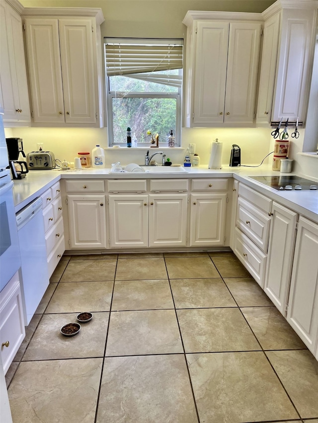 kitchen featuring light tile floors, dishwasher, and white cabinetry