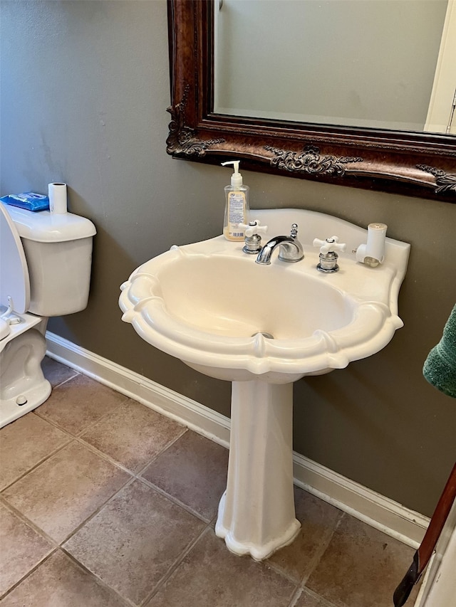 bathroom featuring tile flooring and toilet